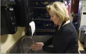  ?? RICH PEDRONCELL­I — THE ASSOCIATED PRESS ?? Brenda Luntey washes her hands while working at the San Francisco Deli in Redding on Dec. 3.