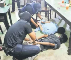  ??  ?? Two of the three suspects being arrested at Pasir Puteh. — Bernama photo