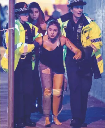  ?? Rex Features via AP Images ?? Police aid an injured woman Monday night at the Manchester Arena after what appears to be the deadliest terrorist attack in Britain since the subway bombings 12 years ago.