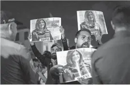  ?? ARIEL SCHALIT/AP ?? Protesters hold photos of journalist Shireen Abu Akleh as they confront Israeli border officers in Haifa. She was killed while covering a raid in the occupied West Bank.