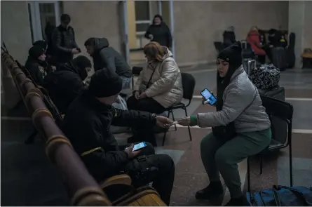  ?? BERNAT ARMANGUE — THE ASSOCIATED PRESS ?? Ukrainian police conduct a security check on train passengers leaving from Kherson to Kyiv at the Kherson railway station on Saturday.