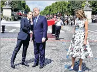  ?? AP PHOTO ?? French President Emmanuel Macron, left, shakes hands with U.S President Donald Trump as First Lady Melania Trump looks on after the Bastille Day military parade on the Champs Elysees avenue in Paris Friday.