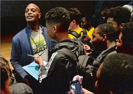  ?? PHOTOS BY DANA JENSEN/THE DAY ?? Above, former New York Giants wide receiver Bobby Johnson looks out over the crowd of ninth-graders wanting his autograph after speaking to them at New London High School on Thursday about his past trouble with drug addiction. Below, Johnson wears the...