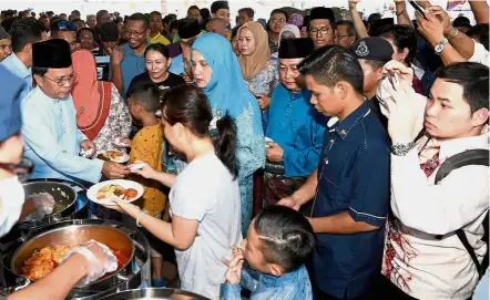  ??  ?? Good turnout: Shafie (left) and his wife Datin Seri Shuryani Shuaib (in blue attire) entertaini­ng guests who turned up for the Hari Raya open house at Menara Tun Mustafah in Kota Kinabalu. — Bernama Datuk Seri Mohd Shafie Apdal