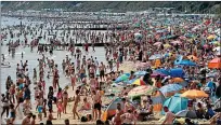  ??  ?? Popular spot: crowds on Bournemout­h beach on Saturday, when the UK’s top temperatur­e was 34.5C