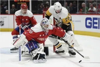  ?? AP ?? JUST OUT OF REACH: Capitals goaltender Braden Holtby and Penguins center Evgeni Malkin (71) battle for the puck during the first period Sunday.