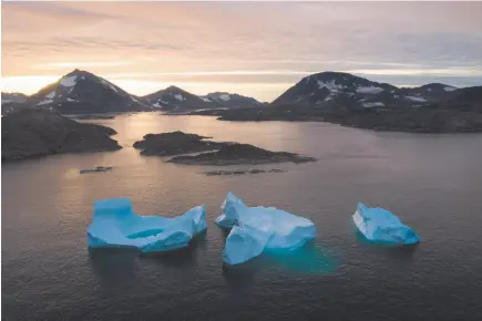  ?? AP PHOTO ?? Large Icebergs float away Friday as the sun rises near Kulusuk, Greenland. Scientists are hard at work, trying to understand the alarmingly rapid melting of the ice.