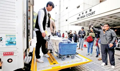  ?? — Reuters photo ?? Policemen deliver evidence relating to rioting charges to the High Court in Hong Kong, China.