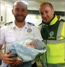  ??  ?? Eugene Cronin(Currow) and Kevin O’Flaherty (Killarney) from Kenmare Ambulance Service with baby Jamie, whom they helped deliver on the side of the road.