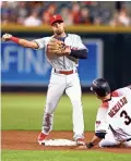  ??  ?? The Phillies’ Cesar Hernandez throws to first to complete a double play Monday against the Diamondbac­ks.