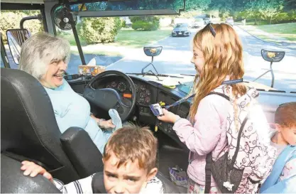  ?? PHOTOS BY CHRIS PEDOTA/NORTH JERSEY.COM, USA TODAY NETWORK – NEW JERSEY ?? Bus driver Margitt Trochey makes a stop Thursday, as Mendham second grader Grace Larsen demonstrat­es swiping a card that logs her into an app to track the bus.