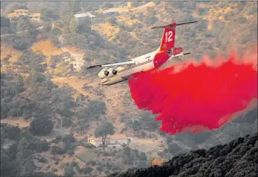  ?? Photograph­s by Al Seib Los Angeles Times ?? A PLANE drops fire retardant Tuesday on the hillsides of the Santa Ynez Mountains above Santa Barbara.