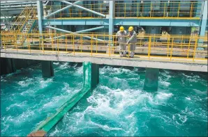  ?? DU YU / XINHUA ?? Two workers inspect the production site of a coal-fired power plant invested by China Huadian Corporatio­n in Bali, Indonesia.