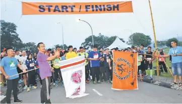  ??  ?? Dr Zamri (second left) officiates at the flag-off for the 12km event.