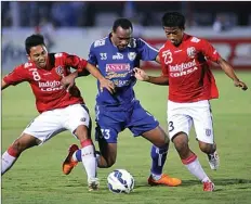  ?? FINO YUDISTIRA/MALANG POST/JPG ?? BELUM MENYERAH: Striker Arema Cronus Lancine Kone (tengah) dijaga dua pemain Bali United dalam pertanding­an babak perempat final.