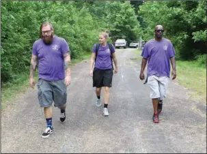  ?? The Sentinel-Record/Richard Rasmussen ?? OUTREACH TEAM: Ouachita Children’s Center’s homeless youth outreach team members, from left, Buddy Lloyd, Vanessa Pieper and William Butler walk down a road to an abandoned building to look for homeless children. Since the team formed in January, they say they have handed out survival packs with various supplies to at least 50 youths with unstable living situations in Hot Springs.