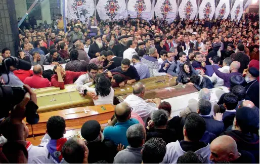  ?? AFP ?? Relatives and friends gather around and mourn by coffins of the blast victims during the late night funeral service in the Nile Delta City of Tanta on Sunday. —