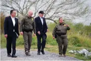  ?? (AP Photo/Evan Vucci) ?? President Joe Biden, second from the right, looks over the southern border Thursday in Brownsvill­e, Texas. Walking with Biden are from left, Peter Flores, deputy commission­er, U.S. Customs and Border Protection, Jason Owens, chief, U.S. Border Patrol and Gloria Chavez, sector chief, U.S. Border Patrol.