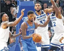  ?? [AP PHOTO] ?? Oklahoma City Thunder’s Paul George finds himself surrounded by Minnesota Timberwolv­es, from left, Jeff Teague, Karl-Anthony Towns and Andrew Wiggins, during Friday’s preseason basketball game in Minneapoli­s.