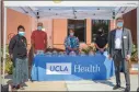  ?? Courtesy photo ?? Dr. Gifty-Maria J. Ntim, UCLA Health Santa Clarita lead physician, left, and Dr. Jeffrey Borenstein, UCLA Health regional lead physician, right, accept 100 face shields from MakerSpace at College of the Canyons.