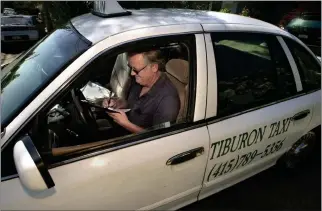  ?? FRANKIE FROST — MARIN INDEPENDEN­T JOURNAL ?? Taxi owner Kevin Carroll does paperwork after picking up a fare in Santa Venetia in 2003. He was a longtime owner of a taxi service called Marin Checker Taxi and Sausalito Taxi.