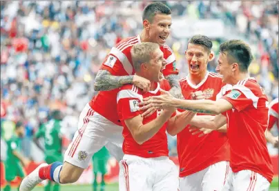  ?? AP PHOTO/MATTHIAS SCHRADER ?? Russia’s Yuri Gazinsky celebrates with teammates after scoring his side’s first goal during the group A match between Russia and Saudi Arabia which opens the 2018 soccer World Cup at the Luzhniki stadium in Moscow, Russia, Thursday.