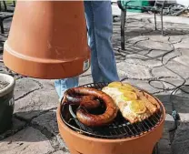  ?? Jerry Lara / Staff photograph­er ?? Holy smoke! The type of smoker Alton Brown of “Good Eats” rigs up with an electric hot plate, a pan of wood chips and two basic terra-cotta flowerpots really works.