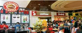  ??  ?? Food World serves favorites from Jollibee, Mang Inasal, Chowking and Highlands Coffee in a food-court gallery.