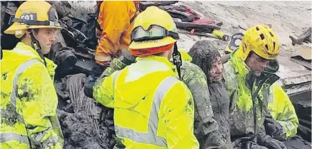  ?? MIKE ELIASON, SANTA BARBARA COUNTY FIRE DEPARTMENT VIA AP ?? Firefighte­rs rescue a mudcaked 14-year-old girl who was trapped for hours Tuesday inside a destroyed home in Montecito, California.