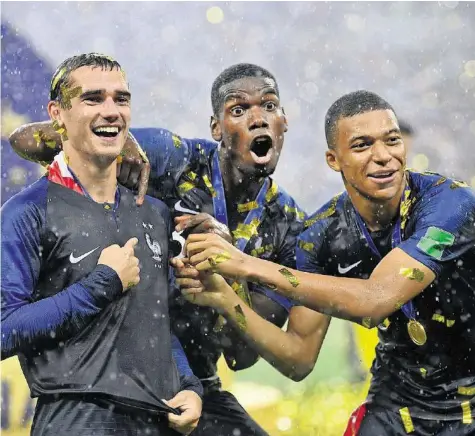  ?? GETTY ?? Zweiter WM-Titel und zweiter Stern für Frankreich: Antoine Griezmann, Paul Pogba und Kylian Mbappé (v.l.) feiern im Regen von Moskau.