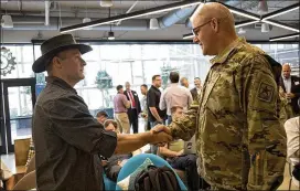  ?? ANA RAMIREZ / AMERICAN-STATESMAN ?? Electric Hat Games CTO Dan Dunham (left) introduces himself to Col. Patrick Seiber at an event Capital Factory hosted last month to introduce plans for the U.S. Army’s new Futures Command tech center in Austin.