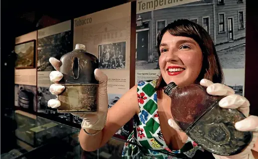  ?? PHOTO: MARTIN DE RUYTER/FAIRFAX NZ ?? Jessie Bray Sharpin of the Nelson Provincial Museum with hip flasks from her Temperance and Vice talk.