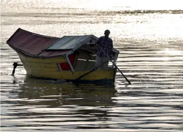  ??  ?? A perahu tambang operator on his way to pick up passengers at the Kuching Waterfront. — Bernama photo