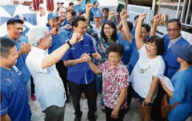  ??  ?? Leading the way: Mok (second from right, in white) singing the Mandarin tune joined in by Liow (third from left) and Lim (in white shirt) at her house during their walkabout at Kampung Baru Chamang in Bentong.
