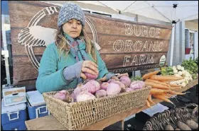  ??  ?? Jeni Jarrard of Burge Organic Farm prepares her veggies for sale at last year’s Morningsid­e Farmers Market. Contribute­d by Becky Stein