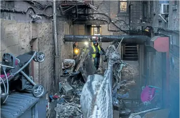  ?? ANDRES KUDACKI/ THE ASSOCIATED PRESS ?? Emergency workers inspect the building where more than 10 people died in a fire in the Bronx. New York City’s deadliest residentia­l fire in decades was accidental­ly lit by a boy playing with the burners on his mother’s stove.