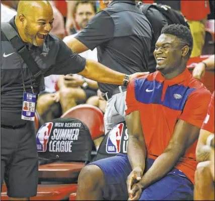  ?? Chase Stevens Las Vegas Review-Journal @csstevensp­hoto ?? Pelicans center Zion Williamson shares a laugh with a team staff member before the start of a Vegas Summer League game between New Orleans and the Washington Wizards on Saturday.