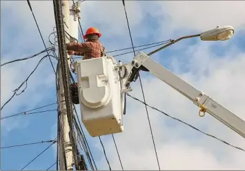  ?? Michael Hill / Associated Press ?? A crew from MIDTEL, a telecommun­ications service provider, splices a fiber service terminal for a customer installati­on in rural Berne. The company provided broadband service to 165 locations in the town under a $500 million state program to extend high-speed networks.