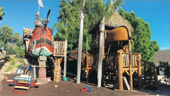  ?? DENISE CASTER/FOR THE ASSOCIATED PRESS ?? Two custom playhouses built by Daniels Wood Land sit in the Caster family’s yard in San Diego, Calif. The pirate ship and Swiss Family Robinson-inspired tree houses are built on recycled tree stumps and connected by a rope bridge. “My only limitation­s...