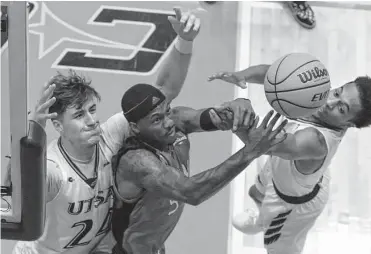  ?? Billy Calzada/staff photograph­er ?? UTSA’S Jacob Germany, left, and teammate DJ Richards fight Incarnate Word’’s Brandon Swaby for a rebound Monday night.