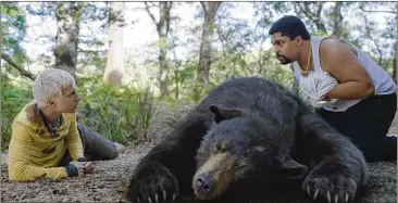  ?? UNIVERSAL PICTURES VIA AP ?? In the movie, Aaron Holliday (left) and O’shea Jackson Jr. are in a scene with the “Cocaine Bear.” Though set in North Georgia, the movie was shot in Ireland. The real bear died, but did not go on a murderous spree.