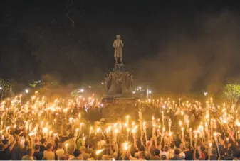  ?? Edu Bayer / New York Times ?? Torch-bearing white nationalis­ts rally near the University of Virginia campus in Charlottes­ville in 2017. Such brazen activities have helped sow division and undermine humanitari­an values.
