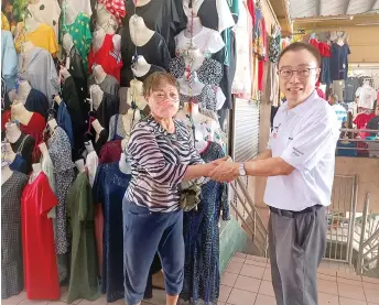  ?? ?? Wong shakes hands with a trader at Sibu Central Market to thank her for her support.