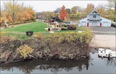  ?? Amy Vaillancou­r / Contribute­d photo ?? Shown is Columbus Point and the boathouses at Harbor Park in Middletown prior to excavation. Erosion of the banks with broken concrete are exposed.