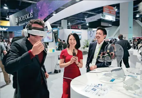  ?? PHOTOS PROVIDED TO CHINA DAILY ?? Ai Cheng (center), founder of iAsk Media, and Liu Zihong (right), CEO of Royole Corp, attend the Consumer Electronic­s Show in Las Vegas, the United States, in January.