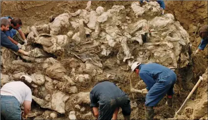  ??  ?? In this Sept. 18, 1996, file photo, Internatio­nal War Crimes Tribunal investigat­ors clear away soil and debris from dozens of Srebrenica victims buried in a mass grave near the village of Pilica, some 32 miles north east of Tuzla, Boisnia-Herzegovin­a. AP PHOTO/STATON R. WINTER