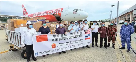  ??  ?? From left: Safar, Liew, Liang, Shafie, Yusof, Wong (seventh left) and others in a photo next to the boxes of face masks donated by the Consulate General of the People’s Republic of China in Kota Kinabalu and four Chinese enterprise­s.