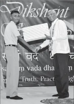  ??  ?? President David Granger presenting Chetram Harrinarin­e, the best graduating CSEC student with a laptop computer. (Ministry of the Presidency photo)