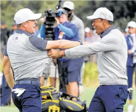  ?? William West / AFP via Getty Images ?? Justin Thomas, left, and Tiger Woods celebrate their victory over Byeong-Hun An and Hideki Matsuyama on Friday in Melbourne, Australia.