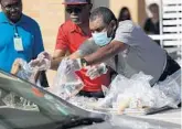  ?? RICARDO RAMIREZ BUXEDA/ORLANDO SENTINEL ?? Orange County Public Schools employees hand out meals to students at Evans High School in March.